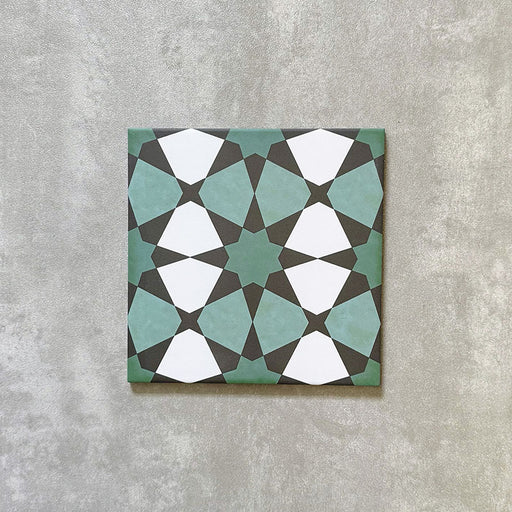 Single Agadir Verde Moroccan-style 20x20cm porcelain tile shown against a neutral background, featuring a geometric star pattern in green, white and charcoal tones.