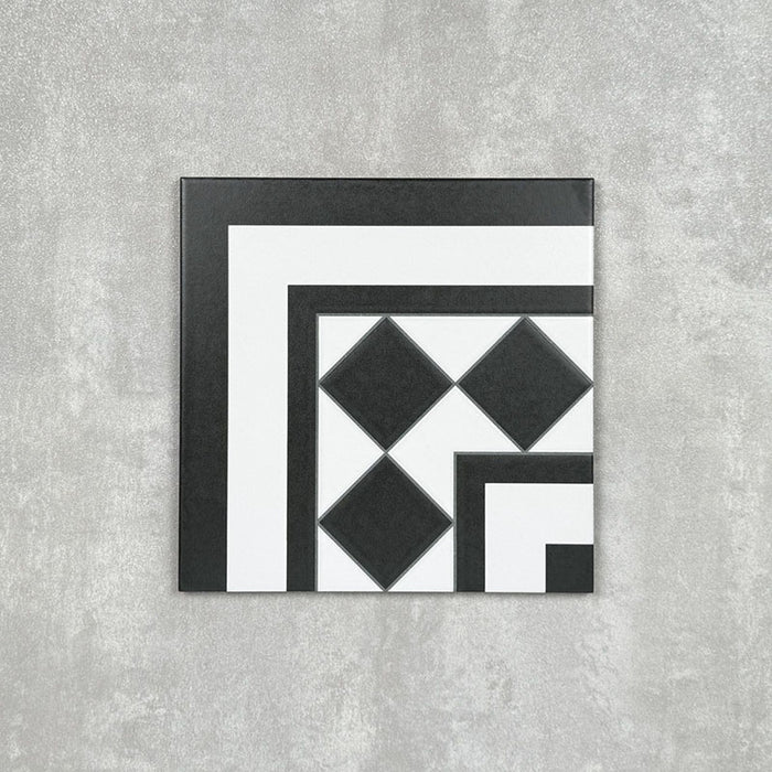 Single Dorset Black & White Victorian-style porcelain corner tile in a 25 × 25cm format, featuring a classic geometric design with contrasting black and white detailing, shown on a neutral background to highlight its use for creating decorative corner borders.