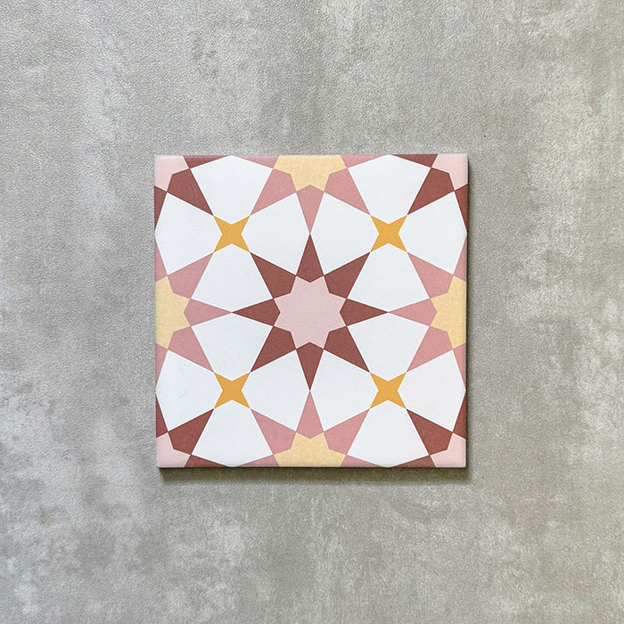 Agadir Springs Moroccan-style 20x20cm porcelain tile featuring a geometric star pattern in soft terracotta, blush pink, white and warm yellow tones, shown as a single tile on a neutral background.