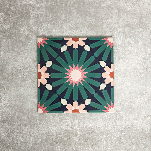 Single Fez Festival 20x20cm Moroccan-style porcelain tile displayed against a textured grey background, highlighting the bold multicolour geometric star pattern in deep teal, pink and warm neutral tones.