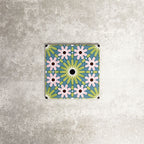 Single Fez Mini Summer 15x15cm Moroccan-style porcelain tile displayed against a textured grey background, highlighting the colourful geometric star pattern in soft green, blue and blush pink tones with an encaustic-inspired finish.