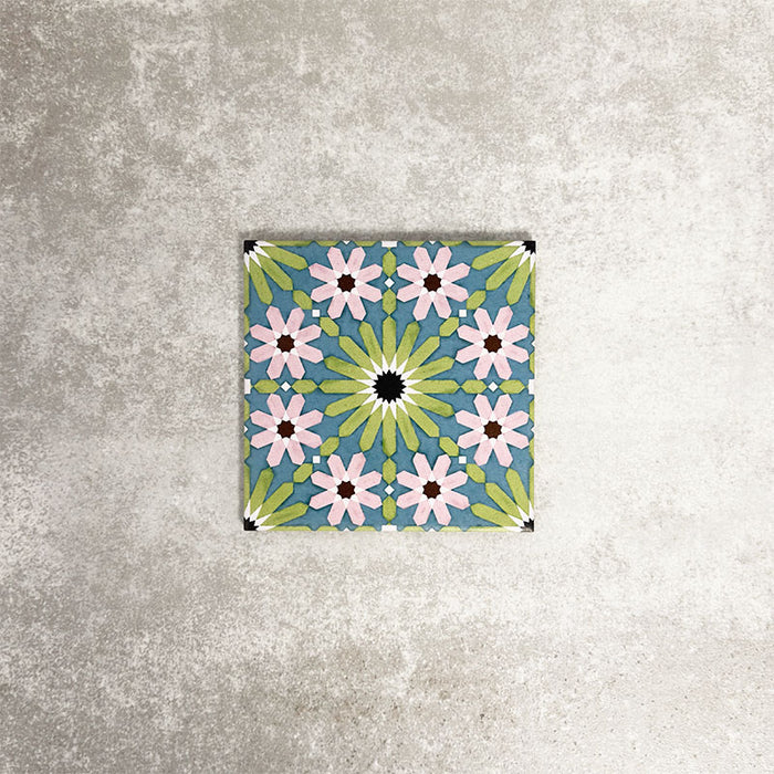 Single Fez Mini Summer 15x15cm Moroccan-style porcelain tile displayed against a textured grey background, highlighting the colourful geometric star pattern in soft green, blue and blush pink tones with an encaustic-inspired finish.