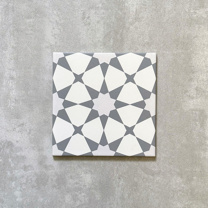 Single Agadir Silver Moroccan-style 20x20cm porcelain tile, featuring a geometric star pattern in soft silver and white tones on a neutral background.