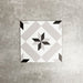 Single Canterbury Star Victorian-style porcelain tile in a 20 × 20cm format, featuring a central star motif in soft grey and black tones on a light background, shown on a neutral surface to highlight the classic geometric design suitable for wall and floor use.
