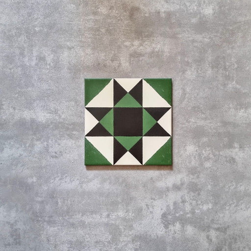 Single Greenbrook Manor anti-slip encaustic Victorian-style porcelain tile, 20 × 20 cm, featuring a bold geometric star pattern in green, black and white on a neutral background.