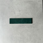 Single Nairobi gloss moss green handmade-effect tile shown close up, highlighting the deep green tone, subtle surface texture and gently uneven edges against a neutral background.