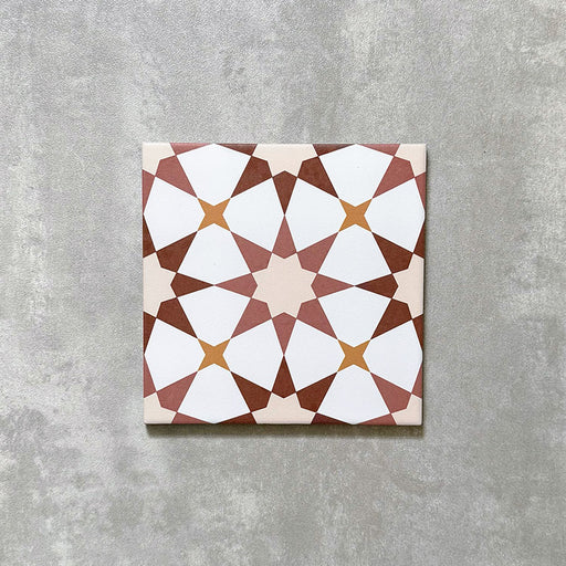 Agadir Cotto Moroccan-style 20x20cm porcelain tile featuring a geometric star pattern in warm terracotta, white and soft yellow tones, shown as a single tile on a neutral background.