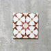 Agadir Cotto Moroccan-style 20x20cm porcelain tile featuring a geometric star pattern in warm terracotta, white and soft yellow tones, shown as a single tile on a neutral background.