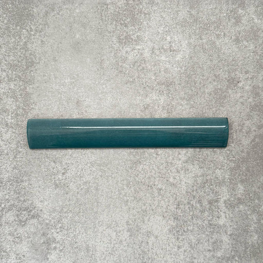 Zellige Peacock Green 3×20cm Moroccan-style ceramic bullnose tile, showcasing the rounded edge profile, deep blue-green glaze and subtle tonal variation on a neutral background.