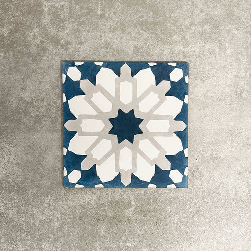 Souk Blue D 20×20cm Moroccan-style porcelain tile with a blue, white and grey geometric pattern.