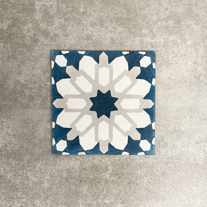 Souk Blue D 20×20cm Moroccan-style porcelain tile with a blue, white and grey geometric pattern.