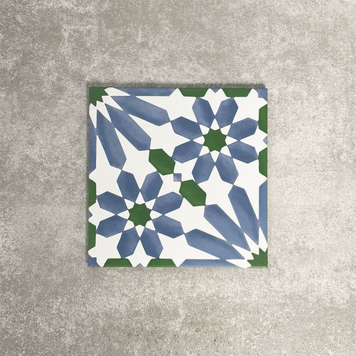 Single Fez Ocean Blue 20x20cm Moroccan-style porcelain tile displayed against a textured grey background, highlighting the blue, white and green geometric star pattern with a traditional encaustic-inspired design.