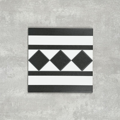 Single Dorset Black & White Victorian-style porcelain border tile in a 25 × 25cm format, featuring a classic striped and diamond geometric design, shown on a neutral background to highlight the contrasting black and white detailing used for decorative borders.