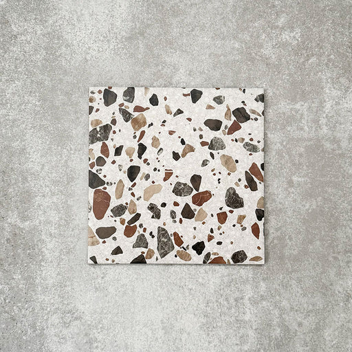 Single Turin Terrazzo Blanco Drops porcelain tile in a 20 × 20cm format, featuring a terrazzo-style design with larger scattered stone fragments in warm neutral tones on a light base, shown on a neutral background to highlight the texture and pattern suitable for wall and floor use.