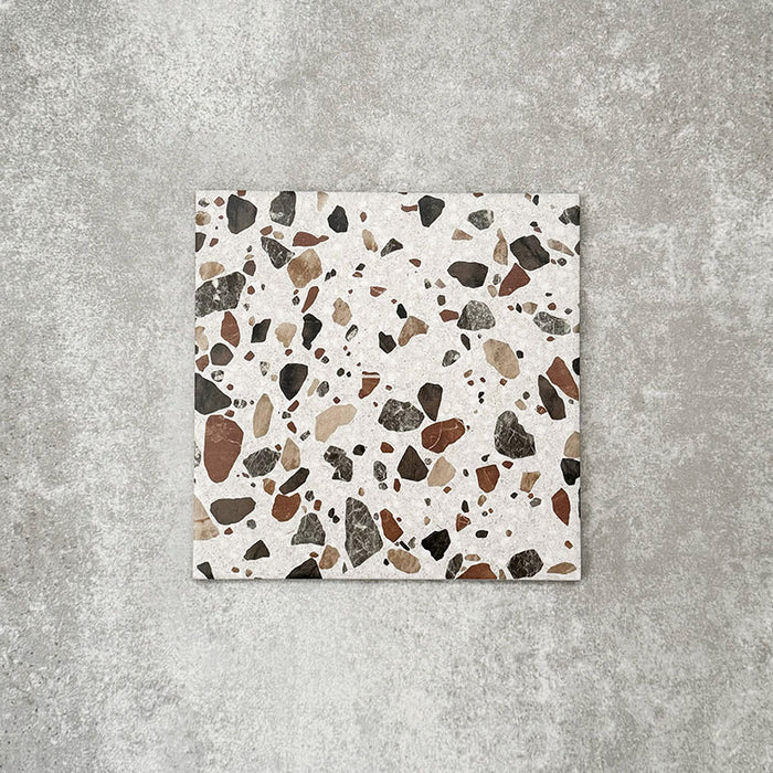 Single Turin Terrazzo Blanco Drops porcelain tile in a 20 × 20cm format, featuring a terrazzo-style design with larger scattered stone fragments in warm neutral tones on a light base, shown on a neutral background to highlight the texture and pattern suitable for wall and floor use.