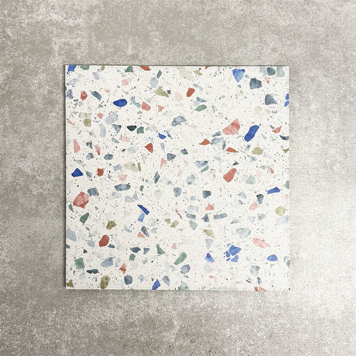Close-up of Gelato Tutti Frutti 25x25cm terrazzo-style porcelain tile, featuring a light neutral base scattered with colourful terrazzo flecks for a playful, contemporary finish.