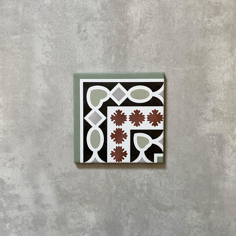 Single Imperial Victorian Green Mini Corner Tile, 15x15cm porcelain tile featuring a classic Victorian-inspired corner pattern in green, black, white, and terracotta tones, photographed on a neutral background.