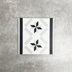 Single Canterbury Star Victorian-style porcelain border tile in a 20 × 20cm format, featuring a repeating star motif framed by contrasting black and grey stripes, shown on a neutral background to highlight its use as a decorative border for wall and floor layouts.