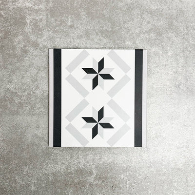Single Canterbury Star Victorian-style porcelain border tile in a 20 × 20cm format, featuring a repeating star motif framed by contrasting black and grey stripes, shown on a neutral background to highlight its use as a decorative border for wall and floor layouts.