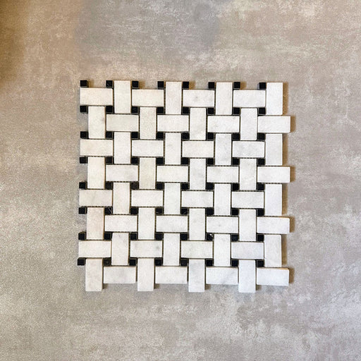 Single Fayrouz Black & White basketweave mosaic natural marble tile with a honed finish, featuring an intricate woven pattern with contrasting dark accents, displayed against a neutral textured background in a clean product setting.