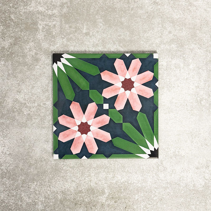 Single Fez Autumn 20x20cm Moroccan-style porcelain tile displayed against a textured grey background, highlighting the rich geometric floral design in deep green, navy blue and blush pink tones with an encaustic-inspired finish.