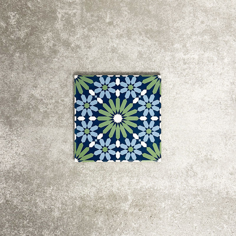 Single Fez Mini Springs 15x15cm Moroccan-style porcelain tile displayed against a textured grey background, highlighting the layered blue and soft green geometric star pattern with an encaustic-inspired finish.
