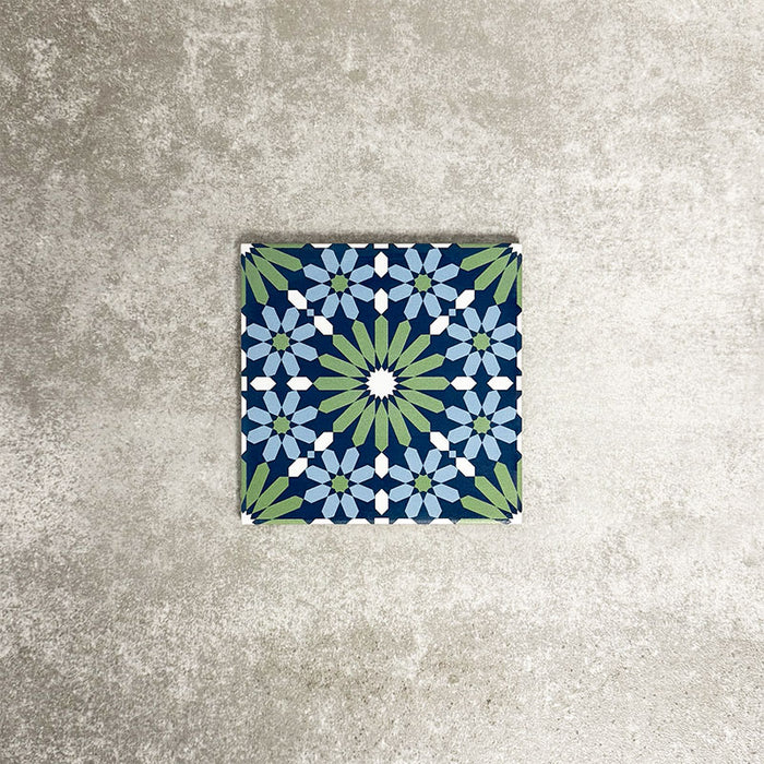 Single Fez Mini Springs 15x15cm Moroccan-style porcelain tile displayed against a textured grey background, highlighting the layered blue and soft green geometric star pattern with an encaustic-inspired finish.