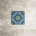 Single Fez Mini Springs 15x15cm Moroccan-style porcelain tile displayed against a textured grey background, highlighting the layered blue and soft green geometric star pattern with an encaustic-inspired finish.