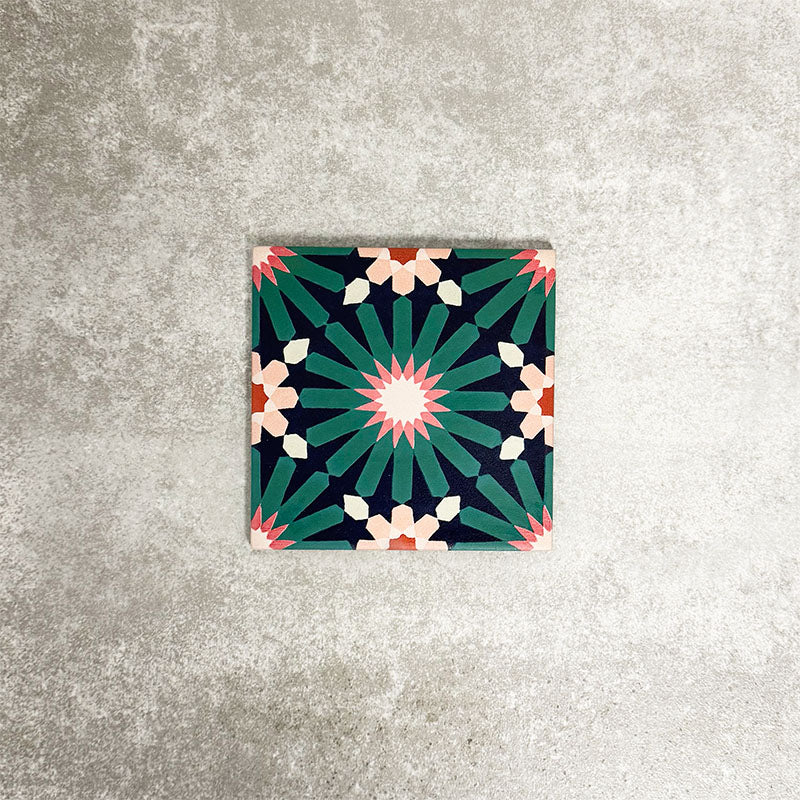 Single Fez Mini Festival 15x15cm Moroccan-style porcelain tile displayed against a textured grey background, highlighting the bold multicolour geometric star pattern in teal, pink and warm neutral tones.