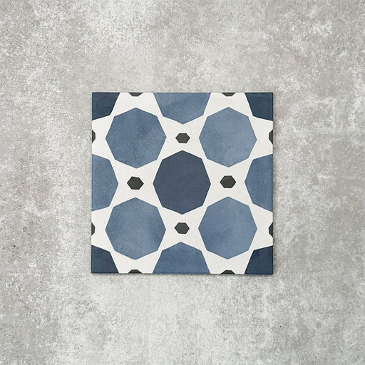 Viscount Sapphire 20×20cm Victorian-style porcelain wall and floor tile featuring a blue and white geometric pattern with octagonal motifs, photographed as a single tile on a neutral grey background.