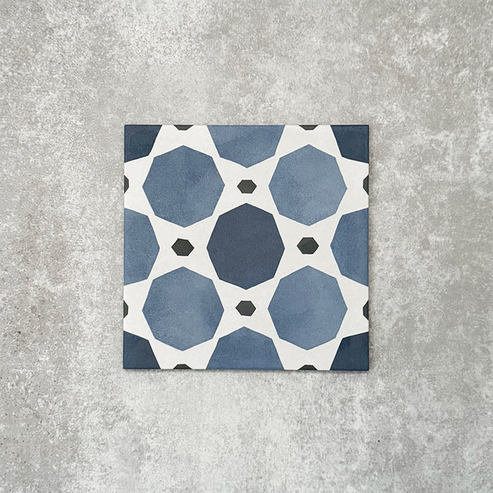 Viscount Sapphire 20×20cm Victorian-style porcelain wall and floor tile featuring a blue and white geometric pattern with octagonal motifs, photographed as a single tile on a neutral grey background.