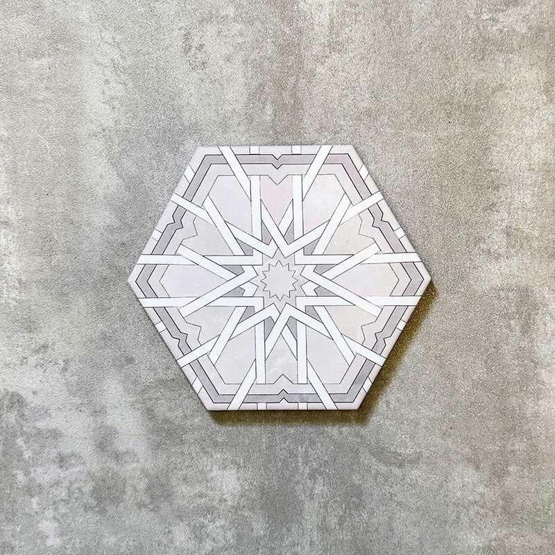 Single Medina Hormuz Snow White Moroccan-style hexagon porcelain tile, 18.7 × 21.6 cm, featuring a crisp star-inspired geometric pattern in white and soft grey tones on a neutral background.