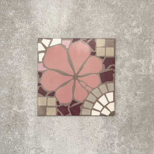 Single Nantes Rose Pink Moroccan-style tile in a 20x20cm format, featuring a soft pink floral motif with petal detailing, surrounded by mosaic-style geometric shapes in warm neutrals and deep burgundy tones, shown on a light grey textured background.