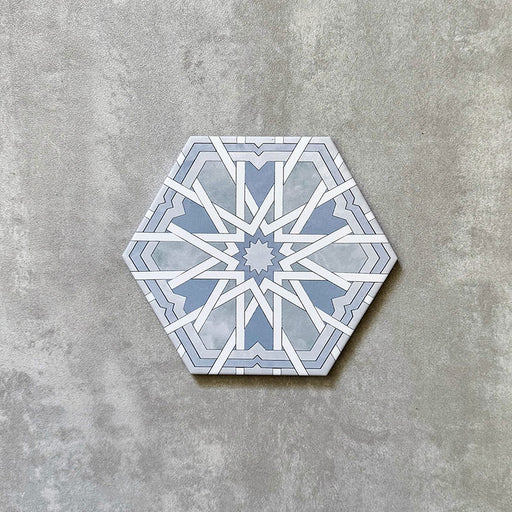 Single Medina Hormuz Azure Blue Moroccan-style hexagon porcelain tile, 18.7 × 21.6 cm, featuring a bold star-inspired geometric pattern in soft blue and white tones on a neutral background.