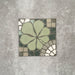 Single Nantes Green Moroccan-style tile in a 20x20cm format, featuring a floral-inspired motif in soft green tones with mosaic-style detailing in muted neutrals and white. A decorative patterned tile ideal for feature walls, floors or statement splashbacks.