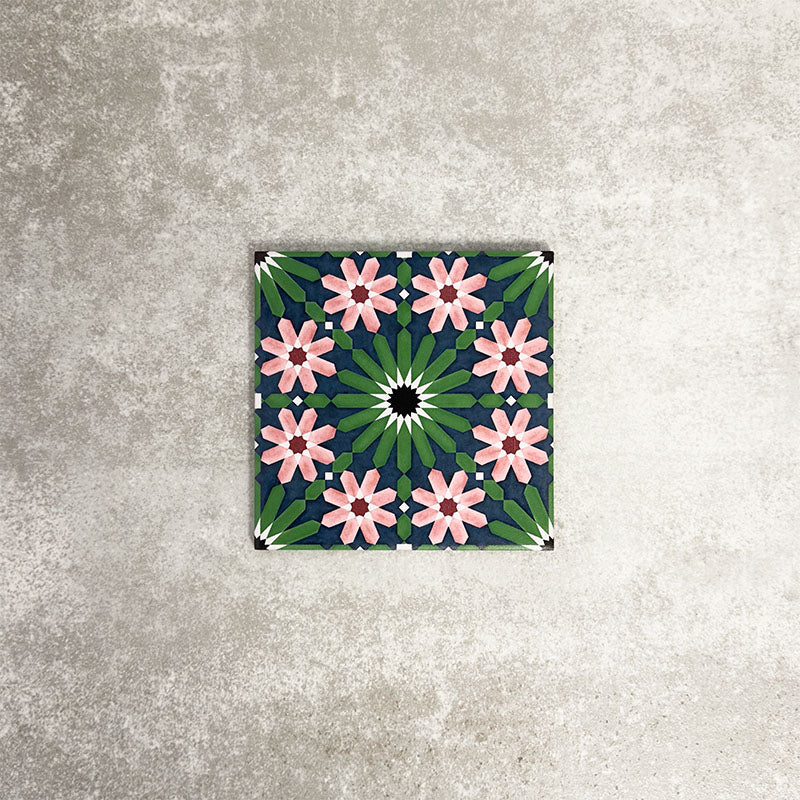 Fez Mini Autumn Moroccan-style porcelain tile shown as a single tile, featuring an intricate geometric star pattern in deep green, soft blush pink, charcoal and white. The 15 × 15cm tile highlights the detailed encaustic-effect design and rich autumnal colour palette, ideal for adding decorative interest to walls or floors.