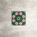 Fez Mini Autumn Moroccan-style porcelain tile shown as a single tile, featuring an intricate geometric star pattern in deep green, soft blush pink, charcoal and white. The 15 × 15cm tile highlights the detailed encaustic-effect design and rich autumnal colour palette, ideal for adding decorative interest to walls or floors.