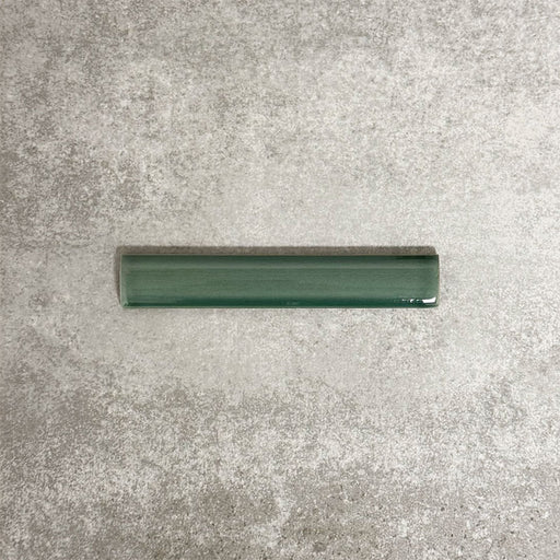Pimlico Golders Green pencil trim tile measuring 2.5 × 15cm, finished with a crackle glaze and deep green tone, designed to neatly frame ceramic wall tiles and add a subtle decorative edge.
