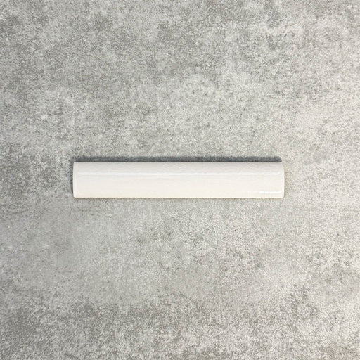 Close-up of Pimlico White 2.5 × 15cm ceramic pencil trim with a crackle glaze finish, showcasing soft white tones and a smooth rounded profile designed to neatly finish tiled wall edges.