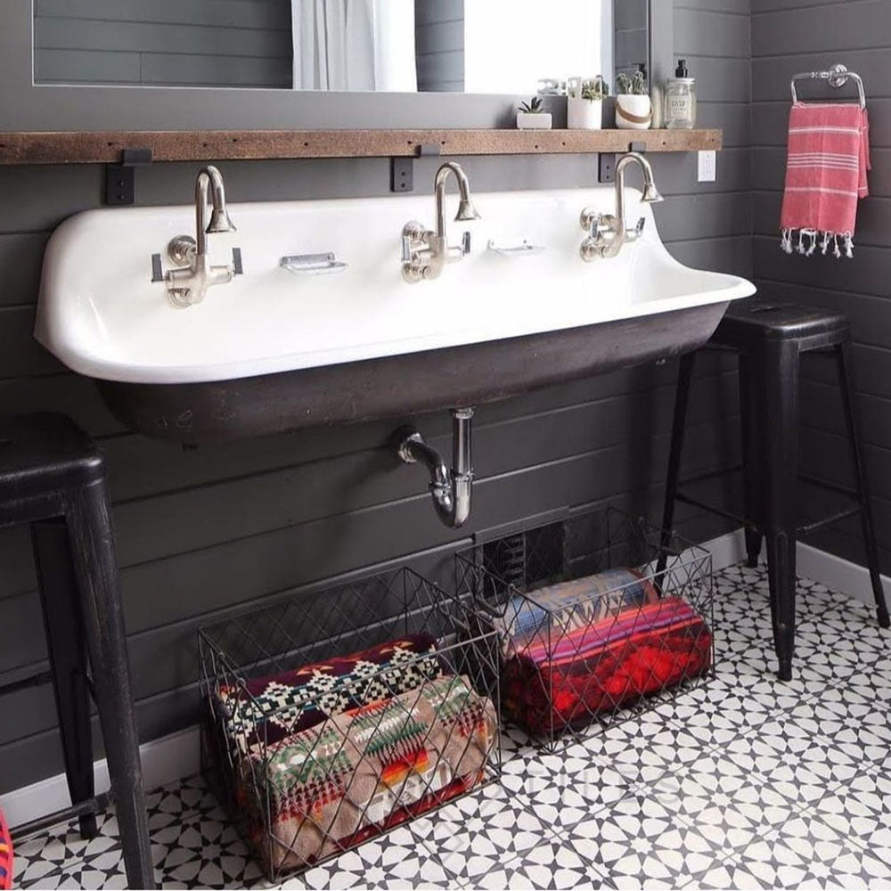Bathroom sink area featuring Agadir Black & White Moroccan-style 20x20cm porcelain floor tiles, showcasing a bold geometric star pattern, styled with a double basin sink, dark wall tiles and industrial accents.