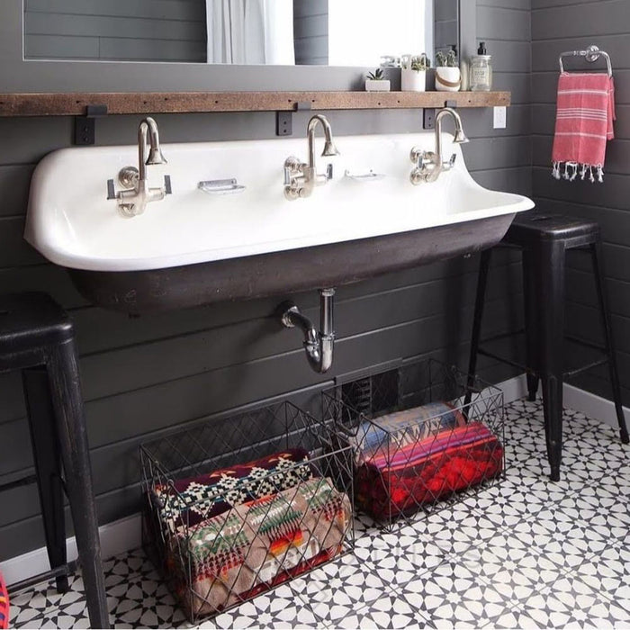 Bathroom sink area featuring Agadir Black & White Moroccan-style 20x20cm porcelain floor tiles, showcasing a bold geometric star pattern, styled with a double basin sink, dark wall tiles and industrial accents.