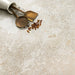 Kitchen surface featuring Essentials Terrazzo Stone Avorio 60x120cm terrazzo effect porcelain tiles, styled with brass utensils, a ceramic container, and warm neutral tones highlighting the soft stone-inspired variation.