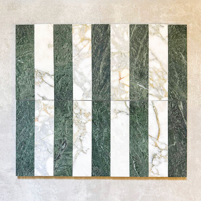 Arrangement featuring Fayrouz Calacatta Green 5x20cm natural marble tiles with a honed finish, displayed in a striped layout alternating green and white marble pieces to highlight natural veining and tonal variation against a neutral backdrop.