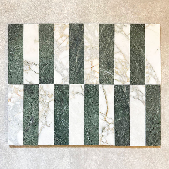 Arrangement featuring Fayrouz Calacatta Green 5x20cm natural marble tiles with a honed finish, displayed in a striped layout alternating green and white marble pieces to highlight natural veining and tonal variation against a neutral backdrop.