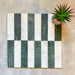 Arrangement featuring Fayrouz White 5x20cm natural marble tiles with a honed finish, paired with green marble pieces in a striped layout, highlighting soft white tones with subtle grey veining alongside rich green variation for contrast and visual interest.