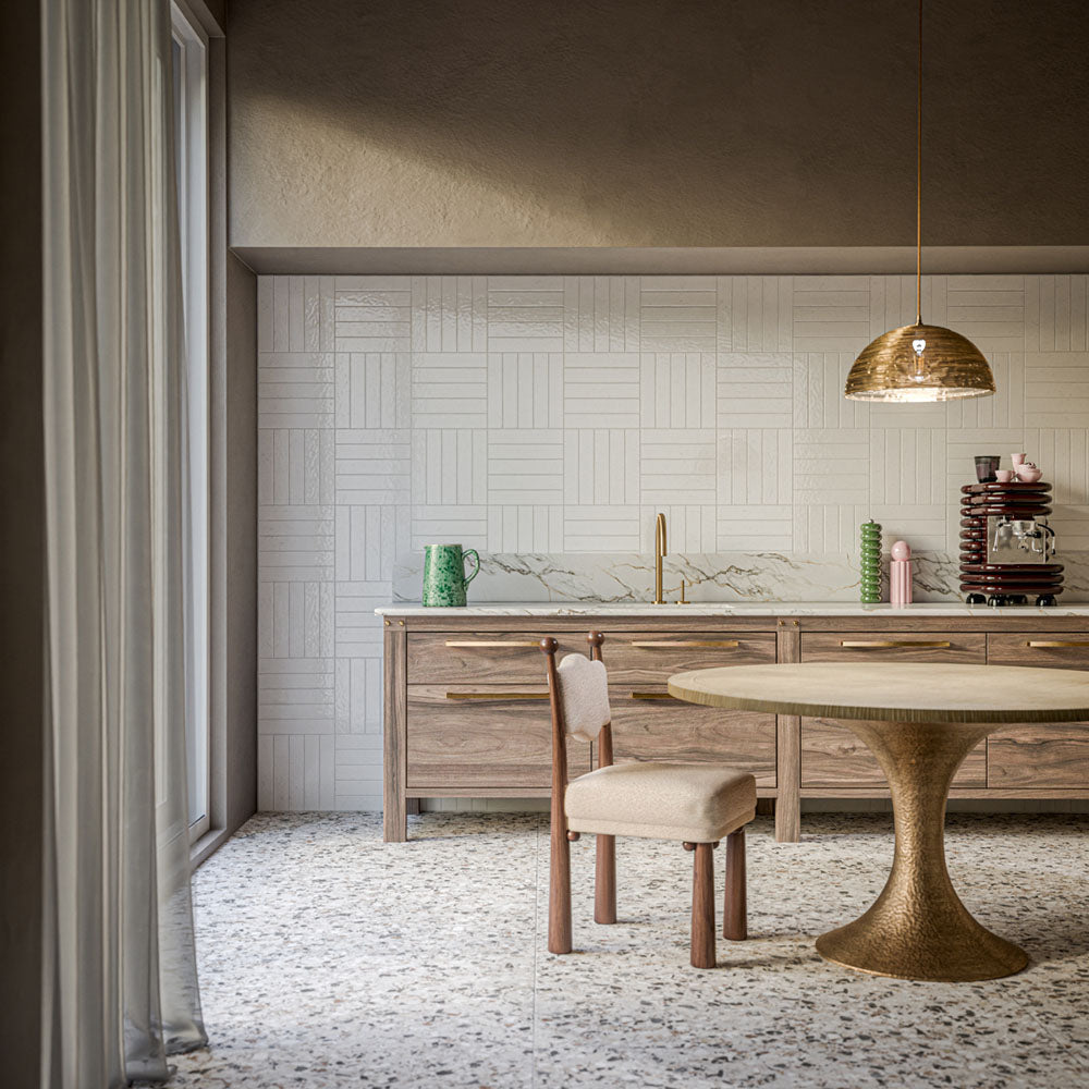 Kitchen featuring Stuzzi Lunar 60x120cm classical terrazzo-effect floor tiles with a 4D brushed finish, paired with white textured wall tiles, natural wood cabinetry, marble-effect worktops and brass accents.