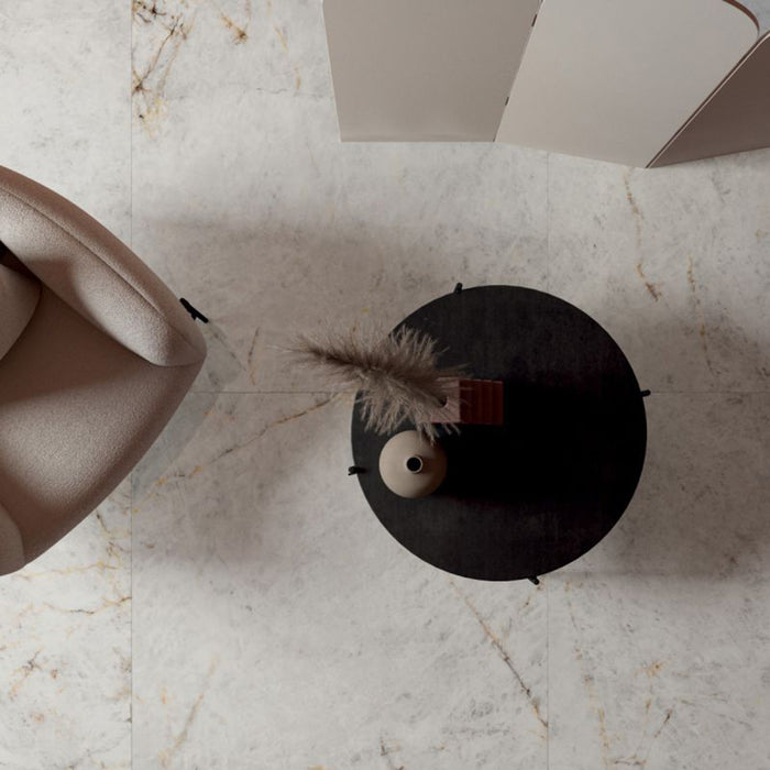Top-down view of Taj Mahal Matt 60 × 120cm marble effect porcelain floor tiles, highlighting soft cream tones with delicate, natural veining. The matt finish creates a smooth, understated surface, complemented by warm furnishings and minimal styling for a refined, contemporary look.