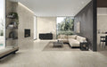 Open-plan living space featuring Taj Mahal Matt 60 × 60cm marble effect porcelain wall and floor tiles, showcasing soft cream tones with delicate, natural veining. The matt finish creates a calm, seamless foundation, complemented by layered textures, warm neutrals, and contemporary architectural lines.