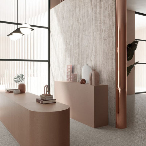 Interior space featuring Taj Mahal Polished Marble effect 60 × 60cm porcelain wall and floor tiles, styled with curved blush-toned furniture, sculptural decor, and soft natural light enhancing delicate veining and texture.
