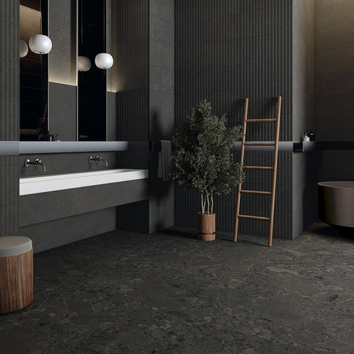 Modern bathroom featuring Terrazerri Terrazzo Black 60x60cm porcelain tiles on the floor and walls. The dark charcoal terrazzo effect creates a bold, contemporary look, paired with fluted wall panels, a floating white vanity, timber accents and soft globe lighting for a sophisticated, luxurious finish.
